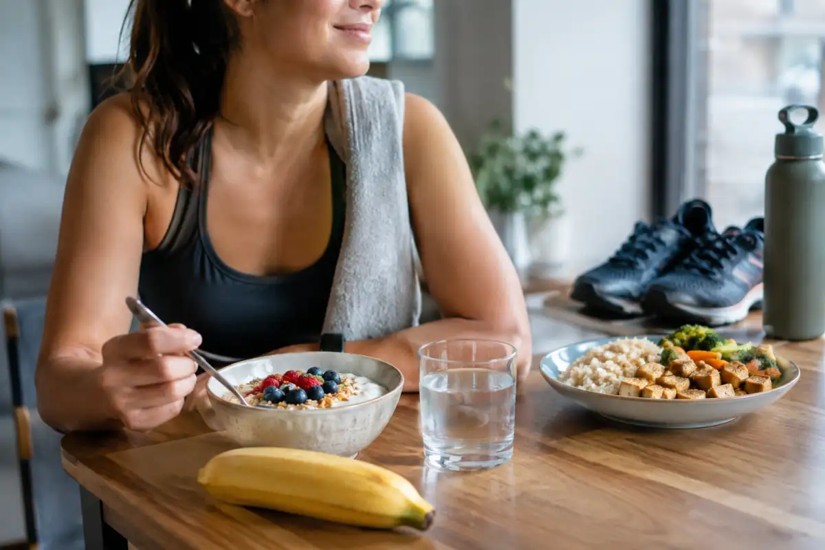 Repas de récupération pour sportif avec yaourt, flocons d’avoine, fruit, riz, tofu et eau après l’entraînement.