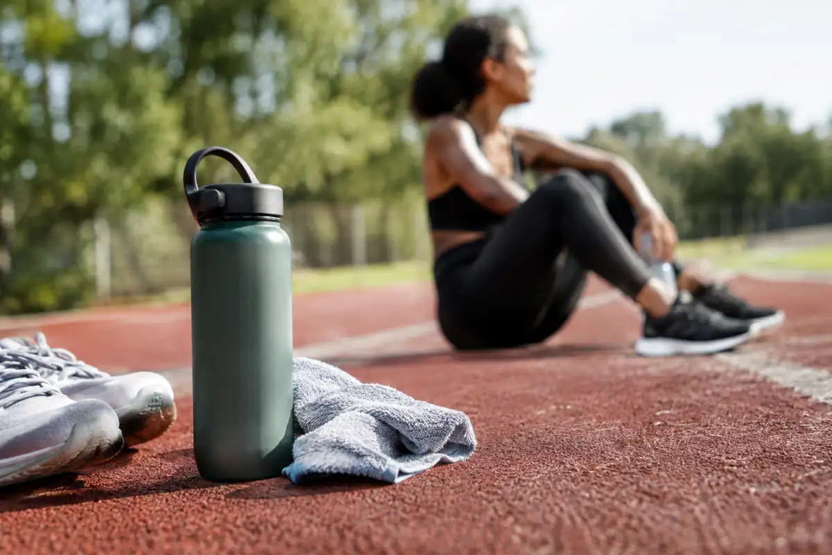 Gourde posée près d’une piste après l’effort, illustrant les repères d’hydratation du sportif pendant une séance.