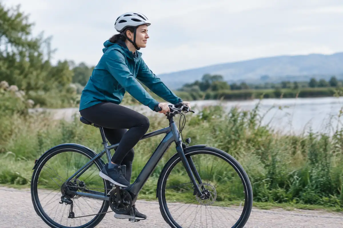 Une personne pédale à allure modérée sur une voie verte, exemple d’activité d’endurance progressive pour soutenir une perte de poids.