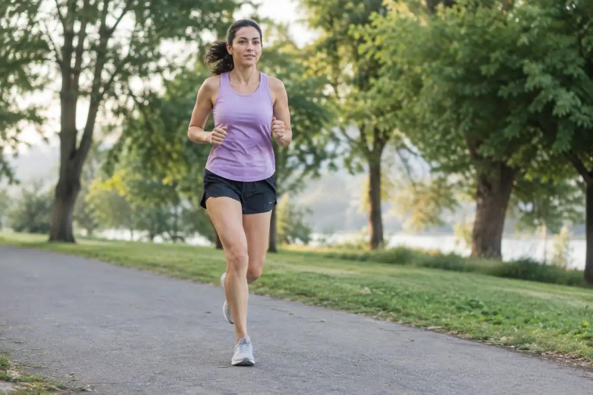Coureur amateur travaillant une foulée relâchée sur un chemin plat, avec une posture naturelle et des appuis proches du corps.