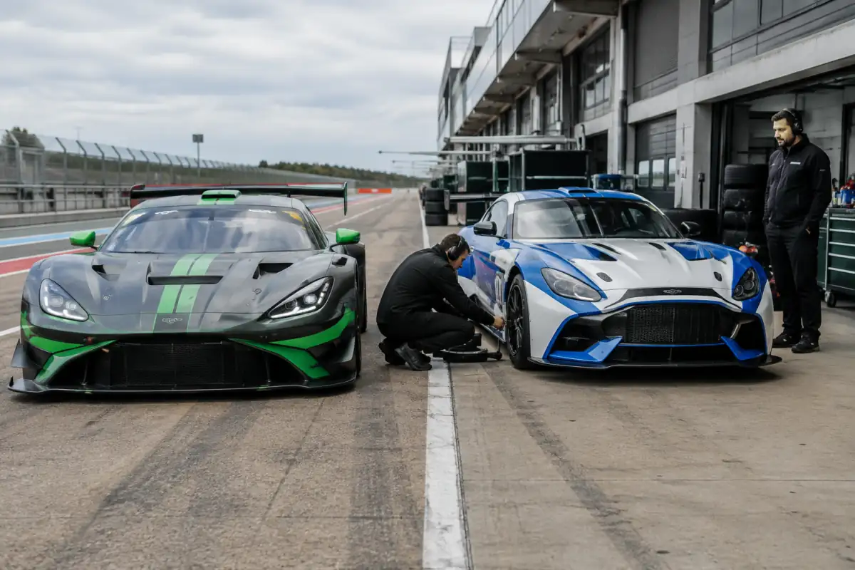 Une GT3 et une GT4 côte à côte dans la voie des stands, avec leurs différences d’aérodynamique et de préparation visibles.