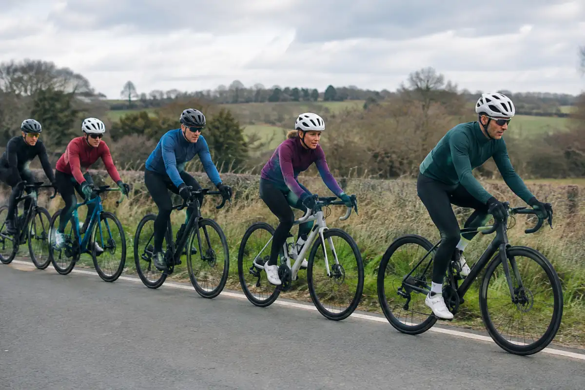 Cyclistes sur route en file décalée : un coureur passe le relais tandis que le groupe maintient des écarts réguliers.
