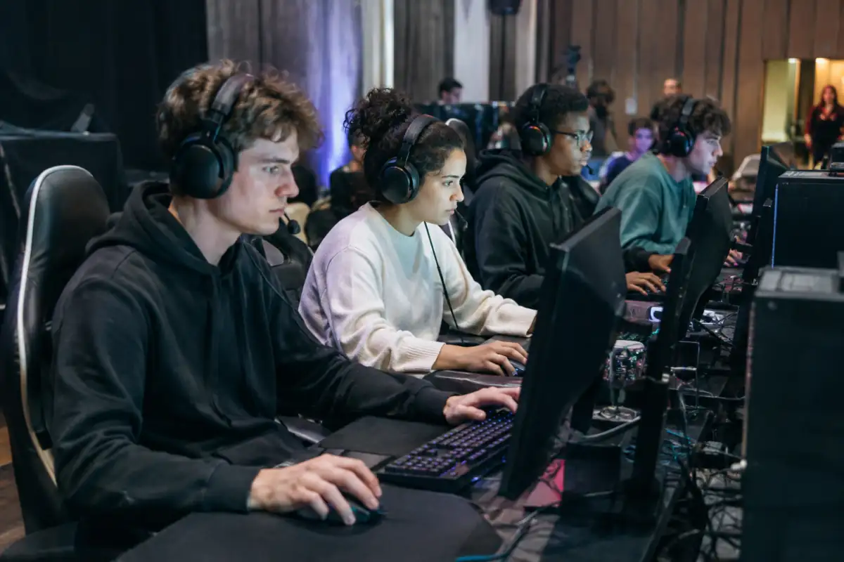 Joueurs d’e-sport en équipe lors d’une compétition en LAN, installés devant leurs ordinateurs et communiquant au casque.
