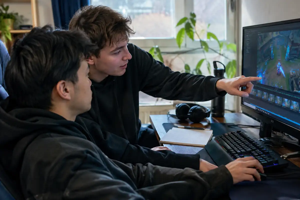 Joueur d’e-sport et coéquipier analysant une séquence de match après un exercice d’entraînement ciblé.