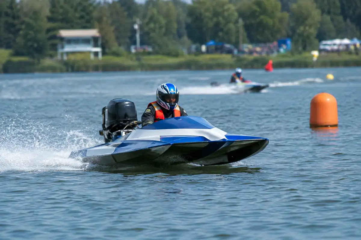 Bateau de course d’endurance motonautique en virage sur un circuit balisé par des bouées, pilote équipé d’un casque et d’un gilet.
