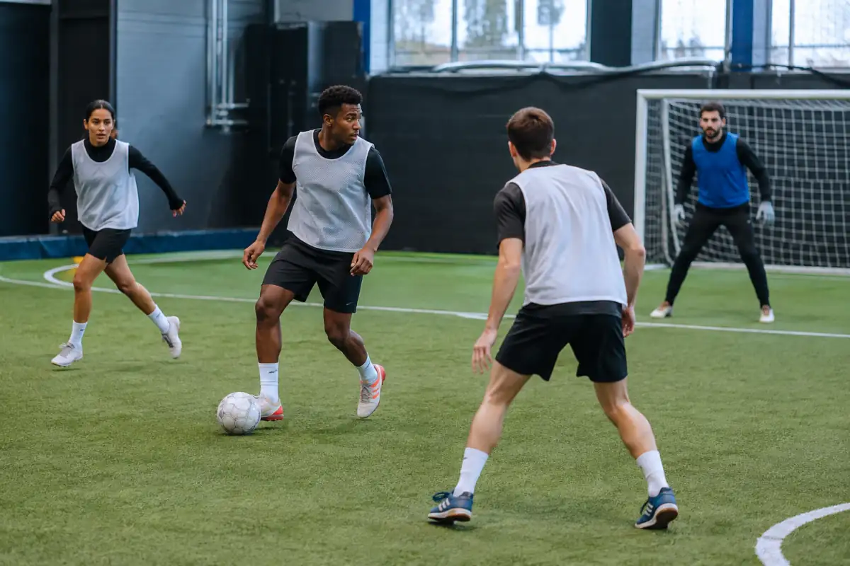 Séance de football à 5 : quatre joueurs en losange travaillent les solutions de passe et la couverture devant leur gardien.