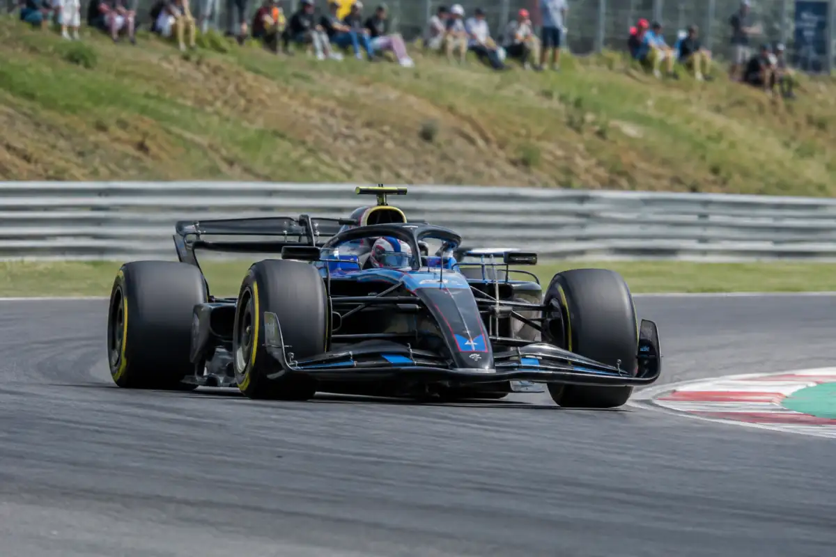 Monoplace de Formule 1 en virage sur circuit, avec pneus slicks, ailerons aérodynamiques et halo de protection autour du cockpit.