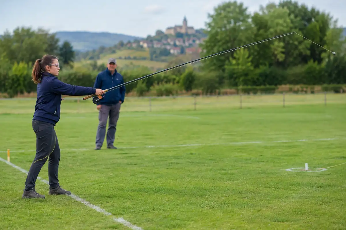 Lancer de compétition : une pratiquante vise une cible avec sa canne sur un terrain dégagé.