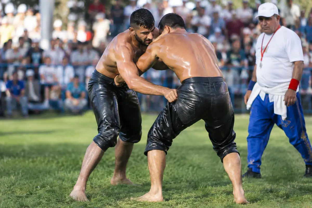 Deux lutteurs de yağlı güreş en kispet s’affrontent sur l’herbe lors d’un tournoi traditionnel turc.