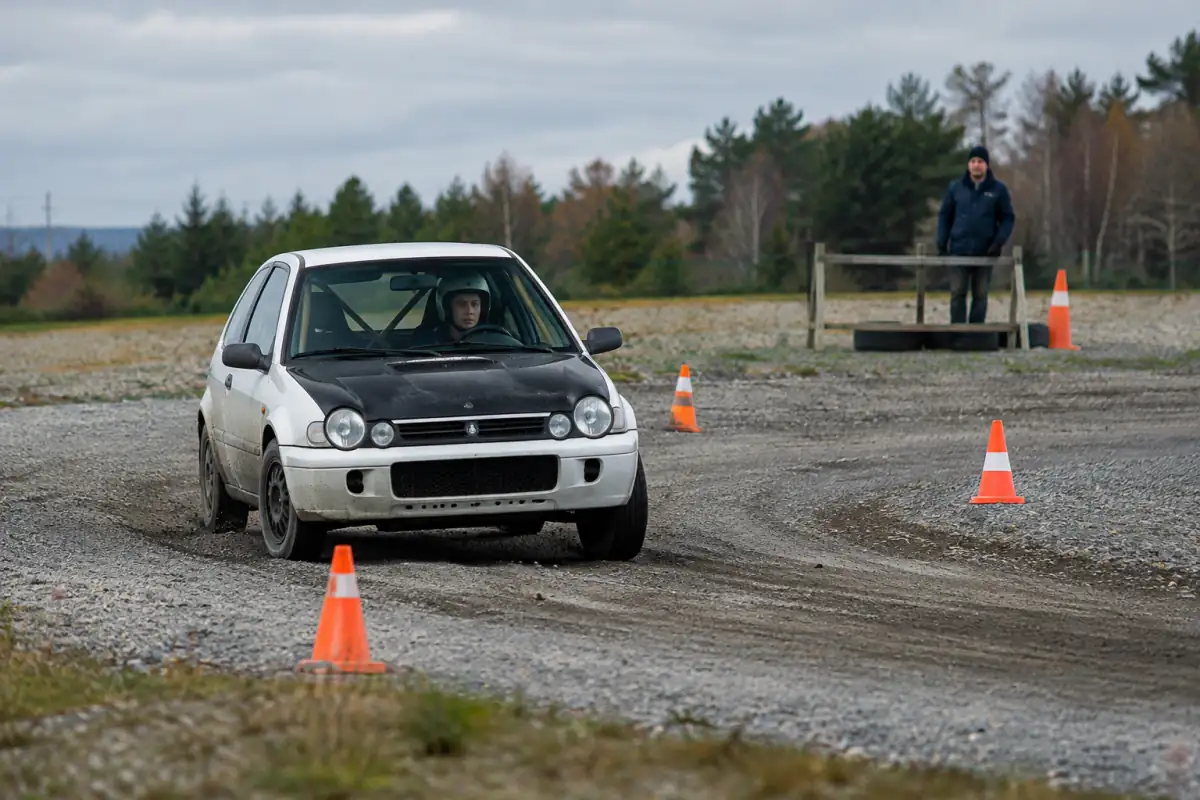 Débutant en voiture de rallye travaillant le regard et le freinage sur un parcours de terre fermé, balisé et encadré.