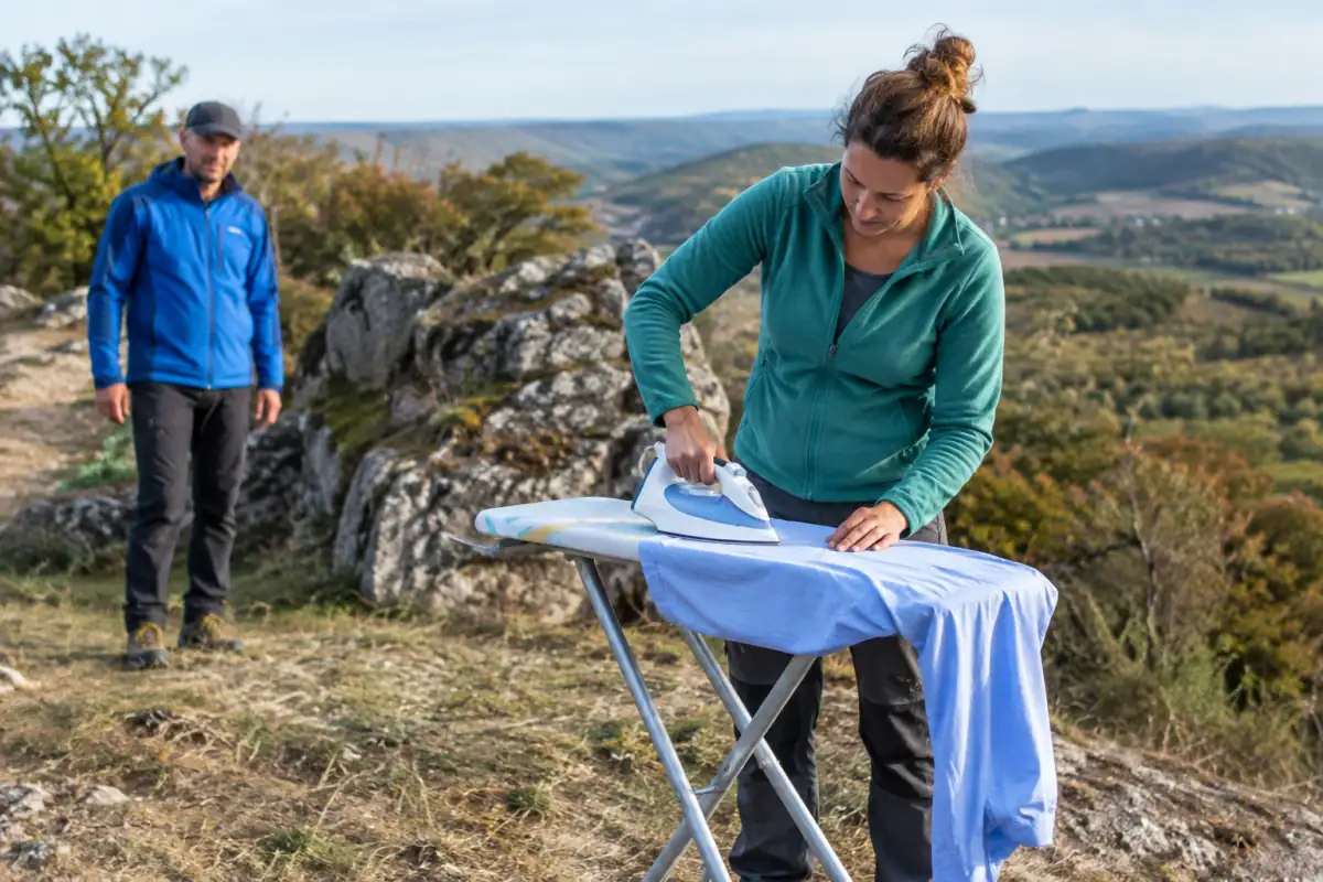 Deux pratiquants réalisent du repassage extrême sur une planche stable, dans un cadre extérieur dégagé et sans danger visible.