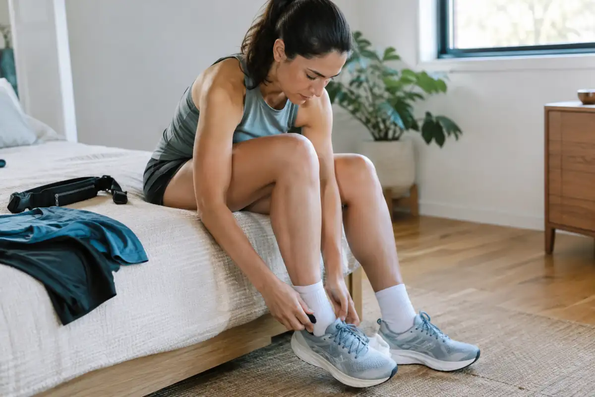 Coureur vérifiant l’ajustement de ses chaussures et chaussettes de course avant un semi-marathon.
