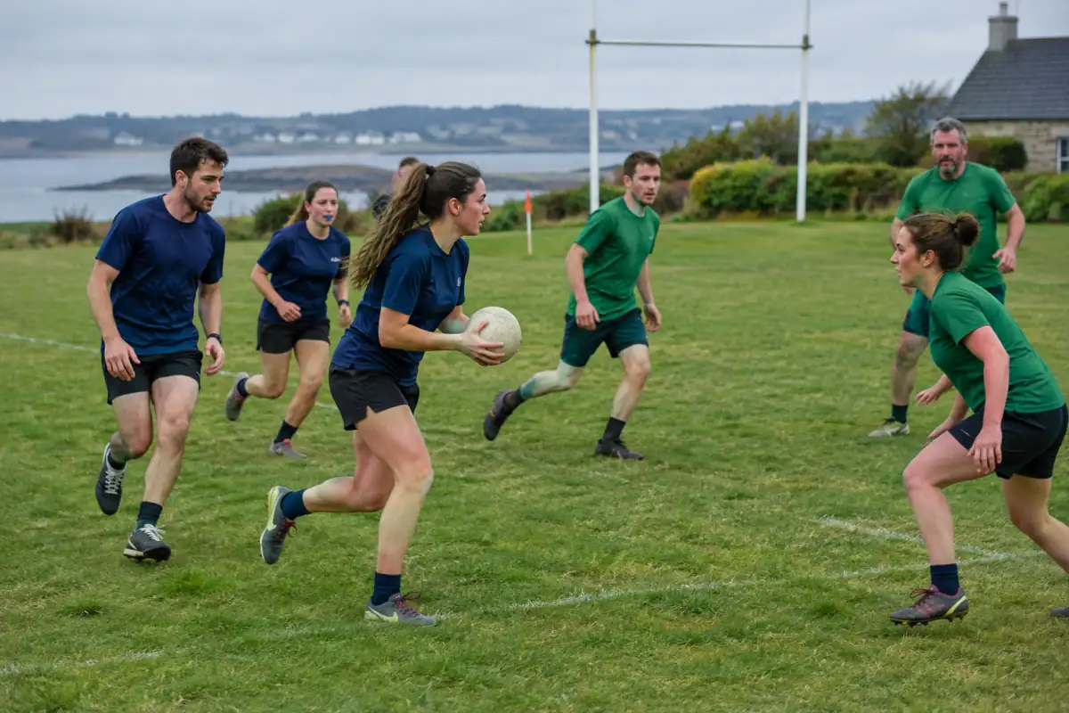 Partie de soule en plein air : des joueurs en tenue de sport progressent avec la balle sur un terrain délimité.