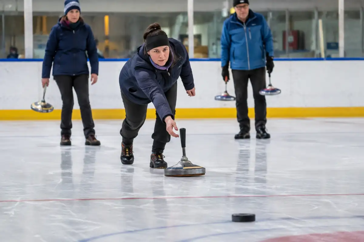 Un joueur lance un stock à poignée sur la glace en direction de la daube, lors d’une partie de sport de palet sur glace.