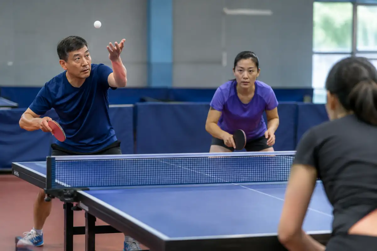 Service diagonal en double au tennis de table : balle lancée sur la paume ouverte, serveur derrière la ligne de fond.