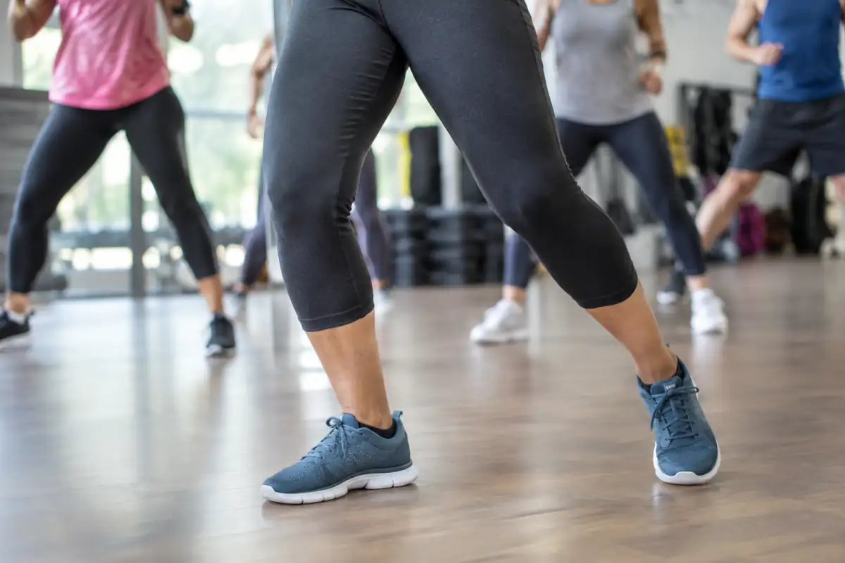 Chaussures de fitness stables pendant un pas latéral en cours de Zumba dans une salle au sol propre.
